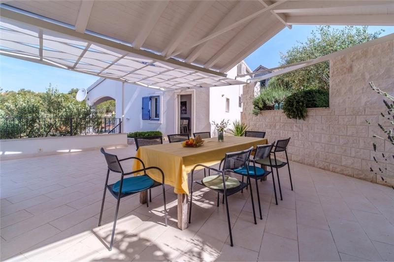 A shaded dining terrace at a villa near Milna, Brač