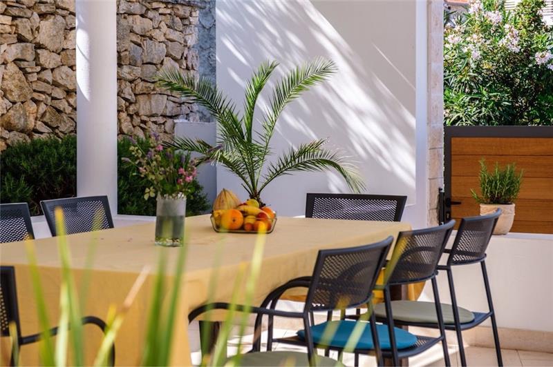 A laid table under the pergola of a villa near Milna, Brač