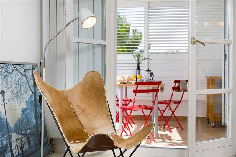 A breakfast table laid with coffee and juice beside open doors to a balcony
