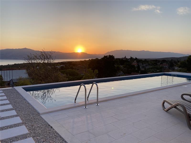 Sunset over the sea channel from a villa pool terrace near Supetar, Brač