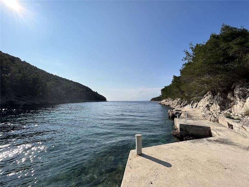 A stone jetty in a quiet pine-backed cove on Hvar