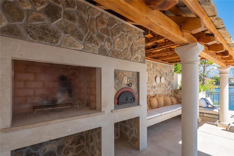 A stone outdoor kitchen with a wood-fired oven above the sea on Brač